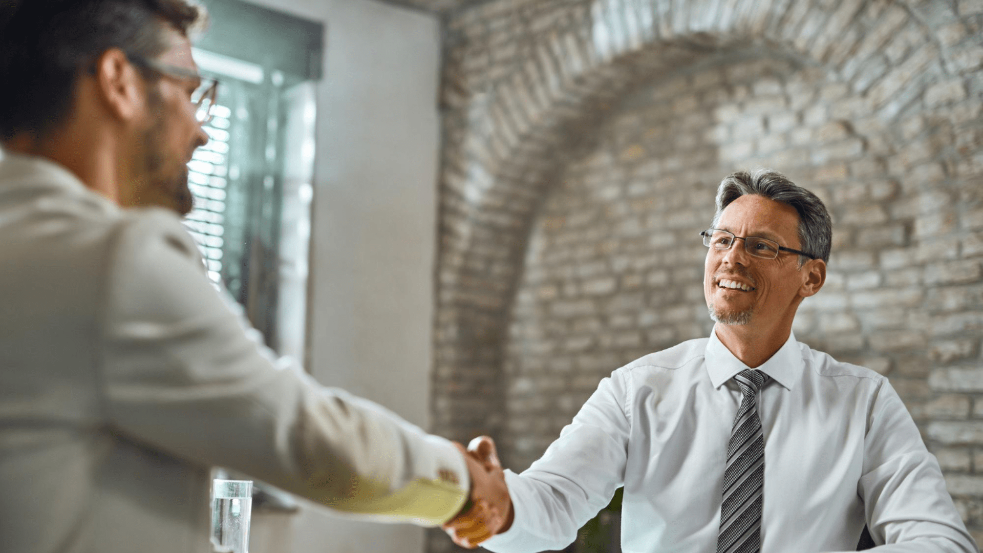 Entrevista de trabajo. Hombres se estrechan la mano.